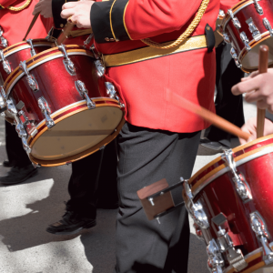 Marching band drummers in vibrant red uniforms performing during a classic holiday parade at the NJ Shore.